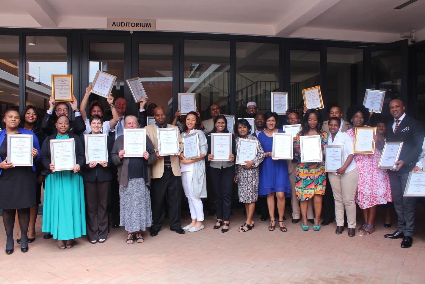 Cheerful staff members showing off their certificates