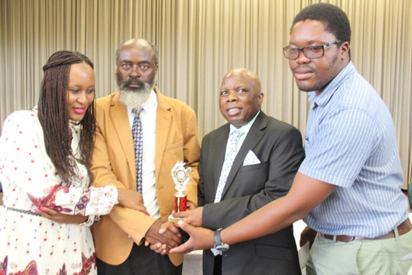 UMlazi District Schools Director, Mr BH Ntuli (in black coat), Departmental Officials, Ms Andiswa Mhlongo and Mr Thandukwazi Ximba congratulates Mr Mbokazi for his achievement.